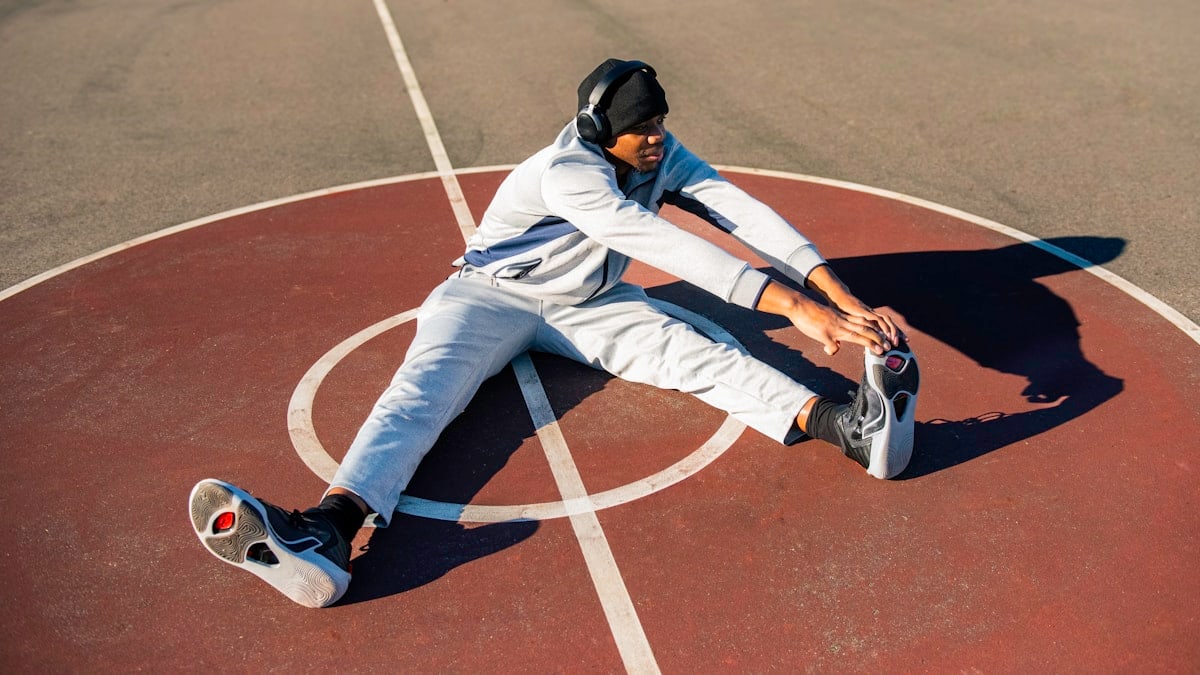 a man sitting on top of a basketball court
